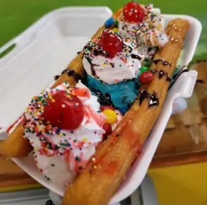Churro split con helado, crema y cerezas