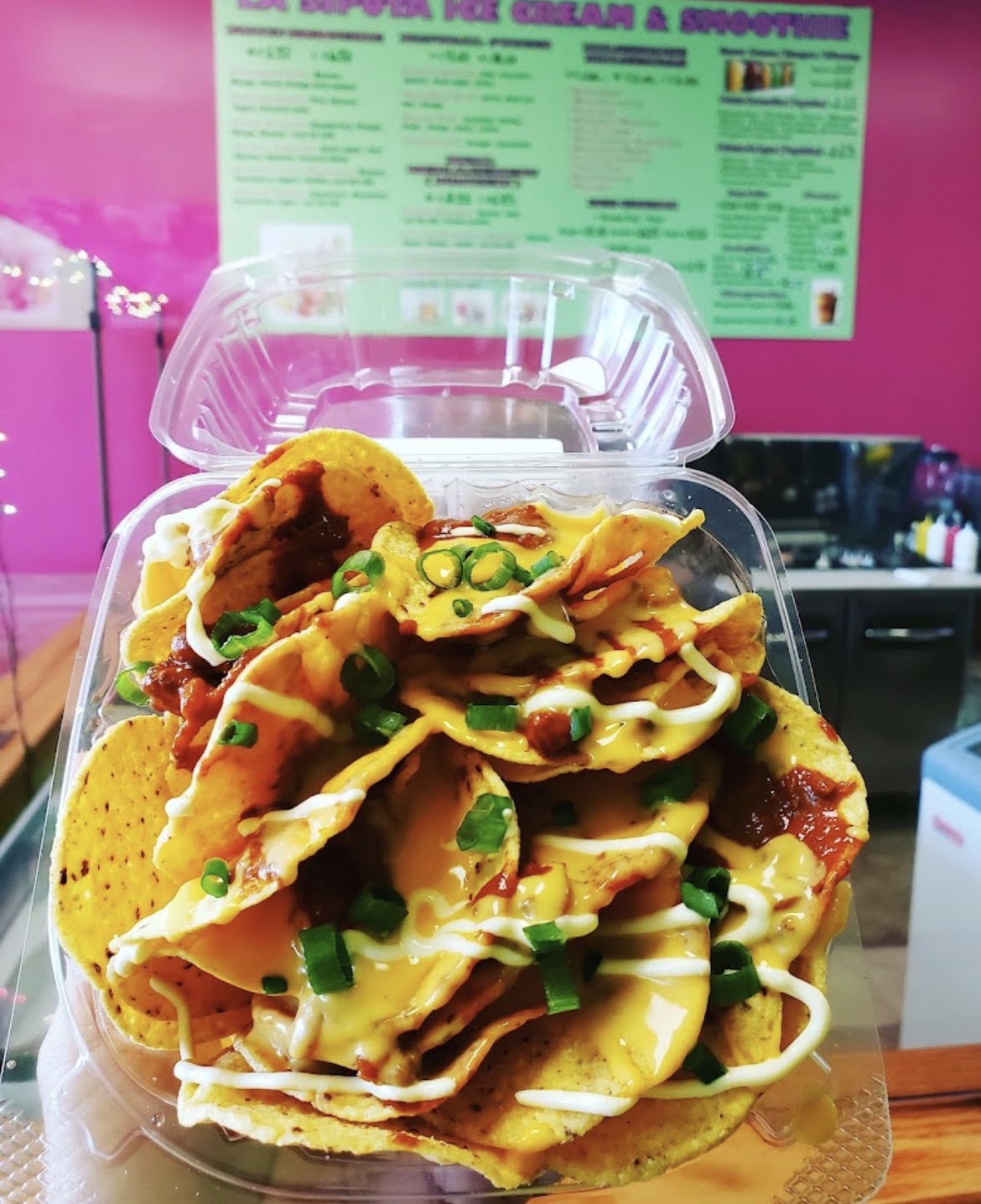 Nachos con queso, salsa, crema y cebollín